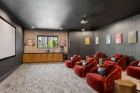 Luxurious home theater with plush red seating, modern decor, and a large projector screen for an ultimate cinematic experience.