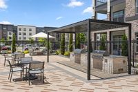 Modern outdoor amenity area with stylish pergola, sleek grills, and comfortable seating, perfect for entertaining and relaxation.