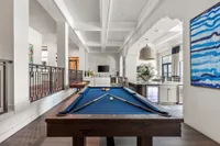 Indoor community area featuring a blue pool table with pool balls and pool sticks