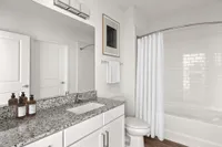 Bathroom with sink and large mirror with a view of the bathtub/shower