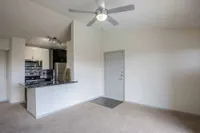 Modern apartment with sleek stainless steel kitchen, stylish ceiling fan, and inviting open layout.