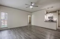Elegant open-plan living area with modern kitchen, sleek hardwood floors, and stylish lighting fixtures.