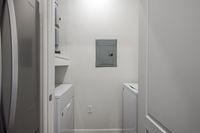 Compact and efficient laundry room with modern appliances and sleek design.