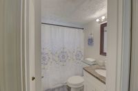 Charming bathroom with stylish patterned shower curtain, elegant granite vanity, and soft towels for a cozy, refreshing experience.
