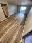Chic living area with elegant wood flooring and natural light from sliding doors, perfect for modern comfort.