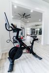 Modern fitness room with sleek exercise bikes, spacious layout, and ample natural light.