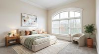 Bright and inviting bedroom with a plush bed, modern decor, large arched window, and cozy reading nook.
