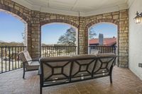 Charming stone terrace with cozy seating and scenic city views, perfect for relaxation and social gatherings.