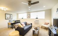 Apartments in West Chester, PA for Rent - Audubon Pointe - Open Living Room With Plush Carpeting, Two Large Windows, and a Ceiling Fan