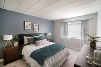 1-Bedroom Apartments in Bethel Park, PA - Lindenbrooke- Bedroom with Carpeted Flooring, Queen Sized Bed, Two Nightstands with Lamps, Dresser, and Large Window.
