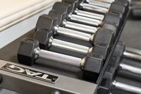 Close-up of a sleek dumbbell set neatly arranged on a rack in a modern fitness center.