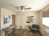 Chic home office with modern desk, stylish artwork, and cozy seating creating an inviting workspace atmosphere.