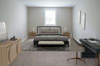 Elegant bedroom with plush carpet, stylish gray bedding, and modern furniture, including a sleek desk and cozy chair.