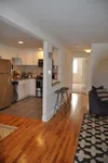 Chic open-concept kitchen with modern stainless steel appliances, elegant barstools, and a cozy living area.