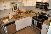 Modern kitchen with sleek stainless steel appliances, elegant granite countertops, and stylish white cabinetry.