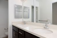 Modern bathroom with a sleek double sink vanity, elegant mirrors, and a bright, minimalist design.