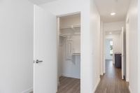 Walk-in closet with ample shelving featuring sleek hardwood flooring and ample natural light.