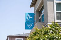 Modern Trio Townhomes South signage on a sunny day, perfect blend of urban and cozy living.