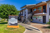 Charming Bonanza Gardens apartment complex with lush greenery, modern balconies, and inviting pathways.