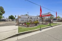 Inviting entrance of Desert Sky mobile home community featuring well-maintained landscaping, vibrant flags, and a welcoming atmosphere in a serene setting.