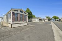 Charming mobile home with classic shutters and inviting steps nestled in a peaceful community setting.