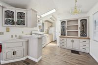 Charming kitchen with elegant cabinetry, ample counter space, and modern appliances, featuring a vintage-style chandelier and natural light.