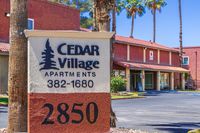 Charming Cedar Village Apartments with desert-inspired architecture, surrounded by palm trees and offering inviting communal spaces.