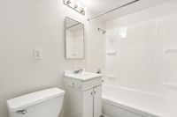 Bright, modern bathroom featuring sleek fixtures, a clean vanity, and a pristine bathtub.