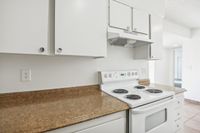 Bright kitchen with white cabinets, modern appliances, and a spacious countertop, perfect for culinary exploration.