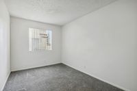 Bright and cozy bedroom with soft carpeting and a large window inviting natural light.