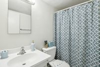 Charming bathroom with elegant blue and white patterned shower curtain, sleek vanity, and contemporary fixtures.