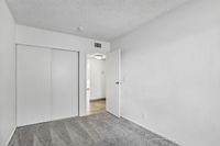 Bright, cozy bedroom with modern sliding closet doors and soft carpet flooring, offering a tranquil retreat.