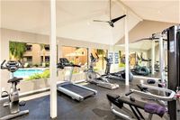 fitness center with exercise equipment and windows overlooking pool at Silver Creek Apartments