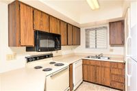 kitchen with vinyl flooring and white appliances and brown cabinets at silver creek