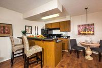 kitchen with breakfast bar and dining area with vinyl wood like flooring at metro on main
