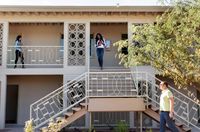 2 story apartment building with woman walking down staircase holding dog at oasis 20