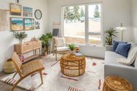 living room with vinyl wood like flooring a grey sofa with a round coffee table and arm chairs on each side and a large rectangular rug