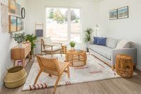 living room with vinyl wood like flooring a grey sofa with a round coffee table and arm chairs on each side and a large rectangular rug