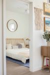 view of inside of bedroom with white bed from hall
