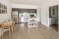 open kitchen with stainless steel appliances and vinyl wood like flooring at twelve mile crossing