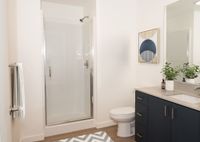 full bathroom with shower with glass door and blue cabinets at twelve mile crossing
