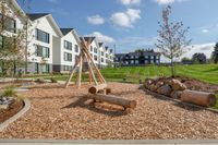 kids play area with wooden balance beams and wooden teepee at twelve mile crossing