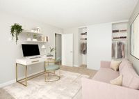 virtually staged image of bedroom with pink sofa and small desk at 81 powell apartments