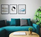 blue sofa with accent pillows and 3 art frames behind on the wall