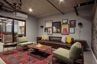 Apartments Near Portland State University - ORO - Lounge with Industrial Style Furniture, Wall Art, and Red Area Rug