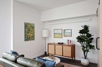 Downtown Portland, OR Apartments - ORO - Living Room with a Leather Sofa, Wood-Style Flooring, and Stylish Decor