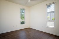 Bedroom with wood flooring and two windows