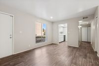 Living area with wood floors, ground floor view, kitchen, and closets