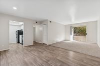 Living area with wood floors, carpet, patio, fridge, oven, and closet