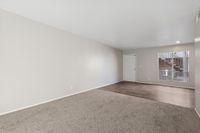 Living area with wooden entrance and carpet with view of stairs
